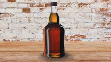 whiskey bottle on wooden shelf with brick background