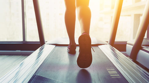closeup of sneakers and legs running on a treadmill