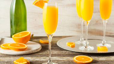 champagne bottle, oranges and mimosa glasses